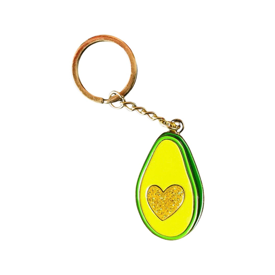 Enamel avocado keychain featuring a gold glitter heart in the center