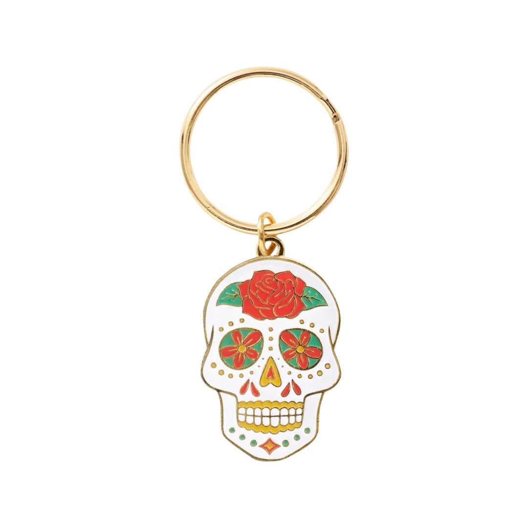 White skull with red rose on forehead and yellow accents on gold key ring.