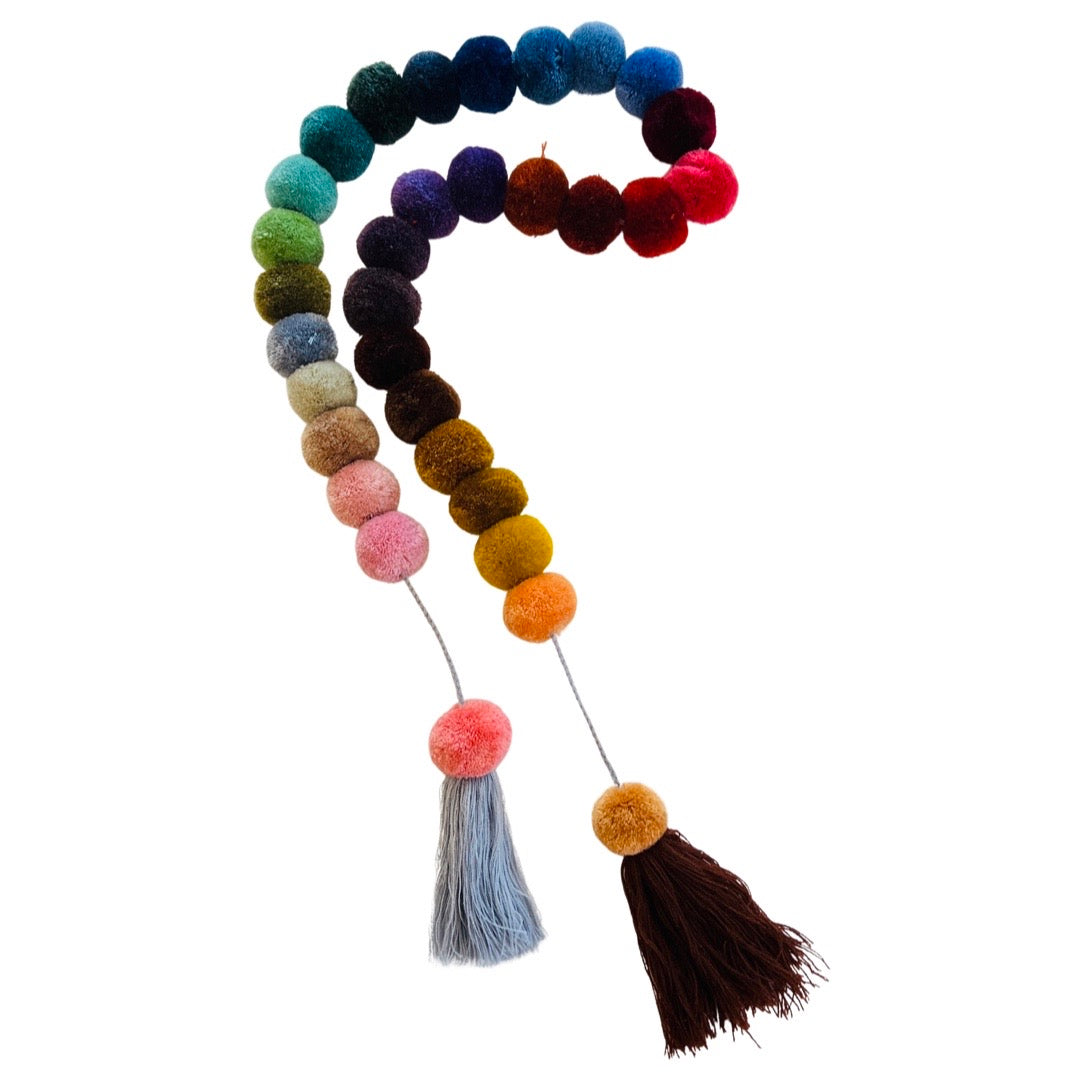 Jewel multi-colored thick pompom garland with tassels on both ends.