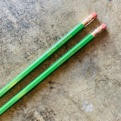 Top view of Como Chingas phrase pencils in bright green.
