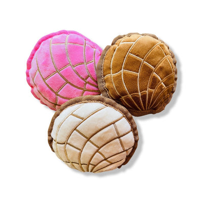 Three plush concha (sweet bread) dog toys featured in pink, brown, and cream.