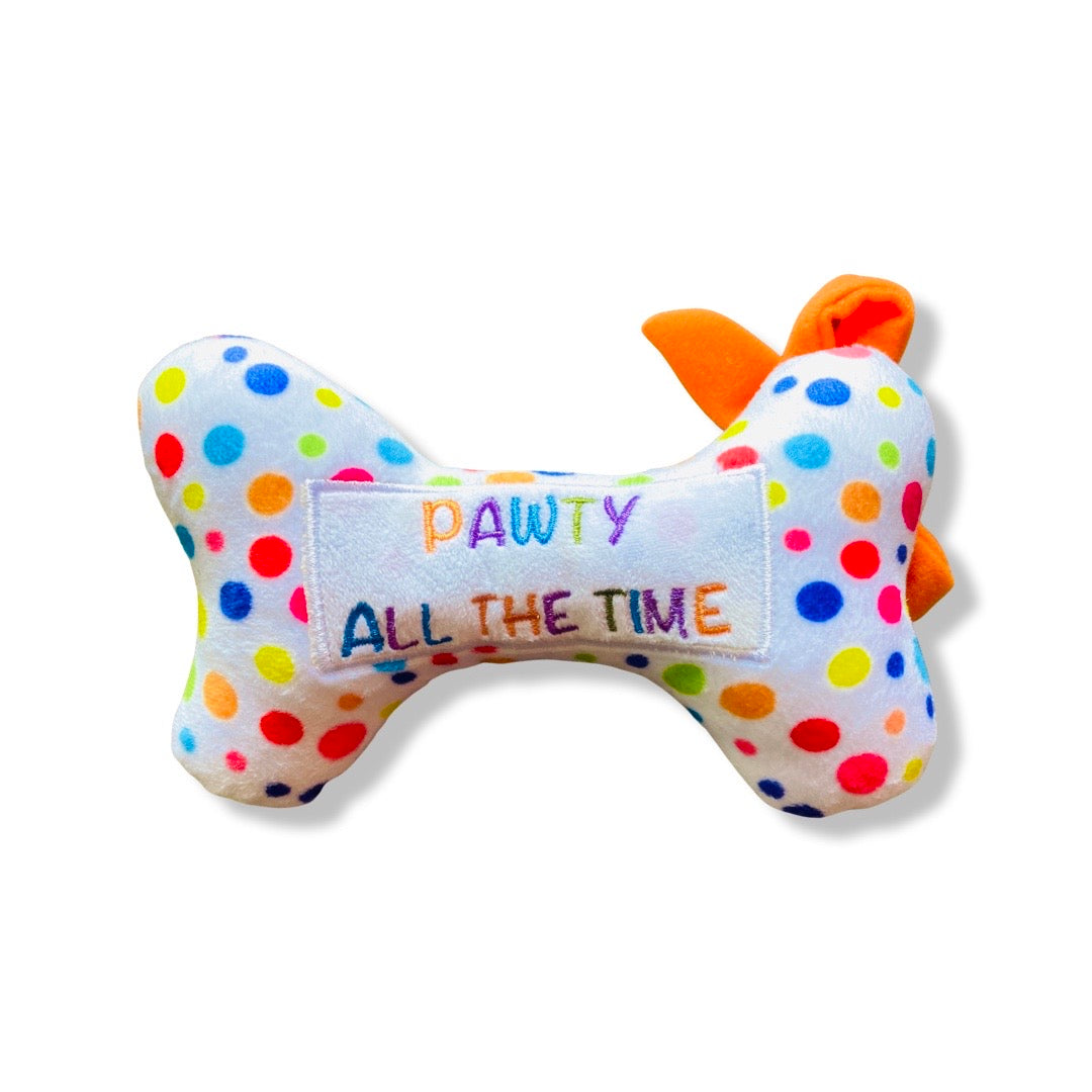 Back view of polka dot plush squeaky dog bone toy reading, "Pawty all the time."