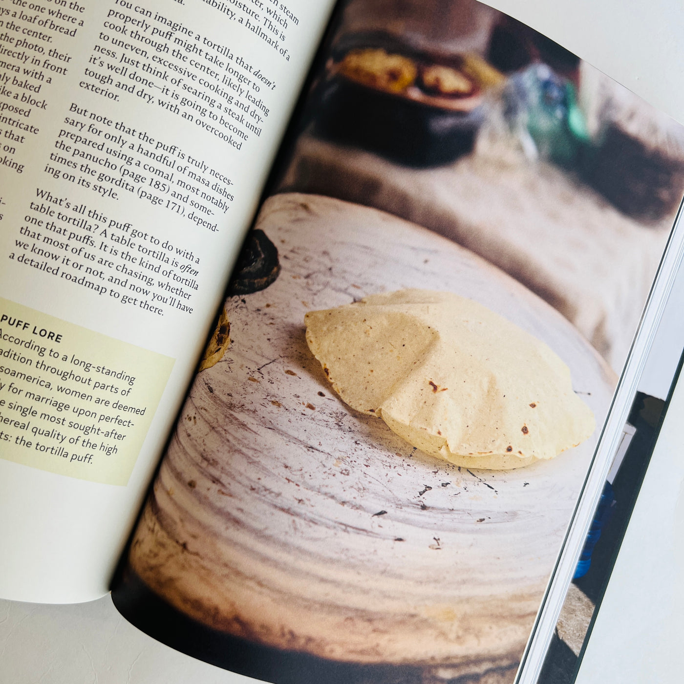 A page of the cookbook with an image of a puffed up corn torilla on a traditional Mexican comal.