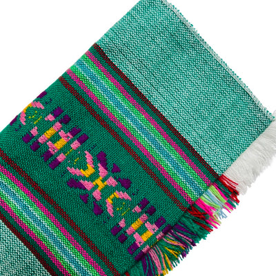 Close up of forrest green Mexican Servilleta. Design features multicolored stripes with pattern.