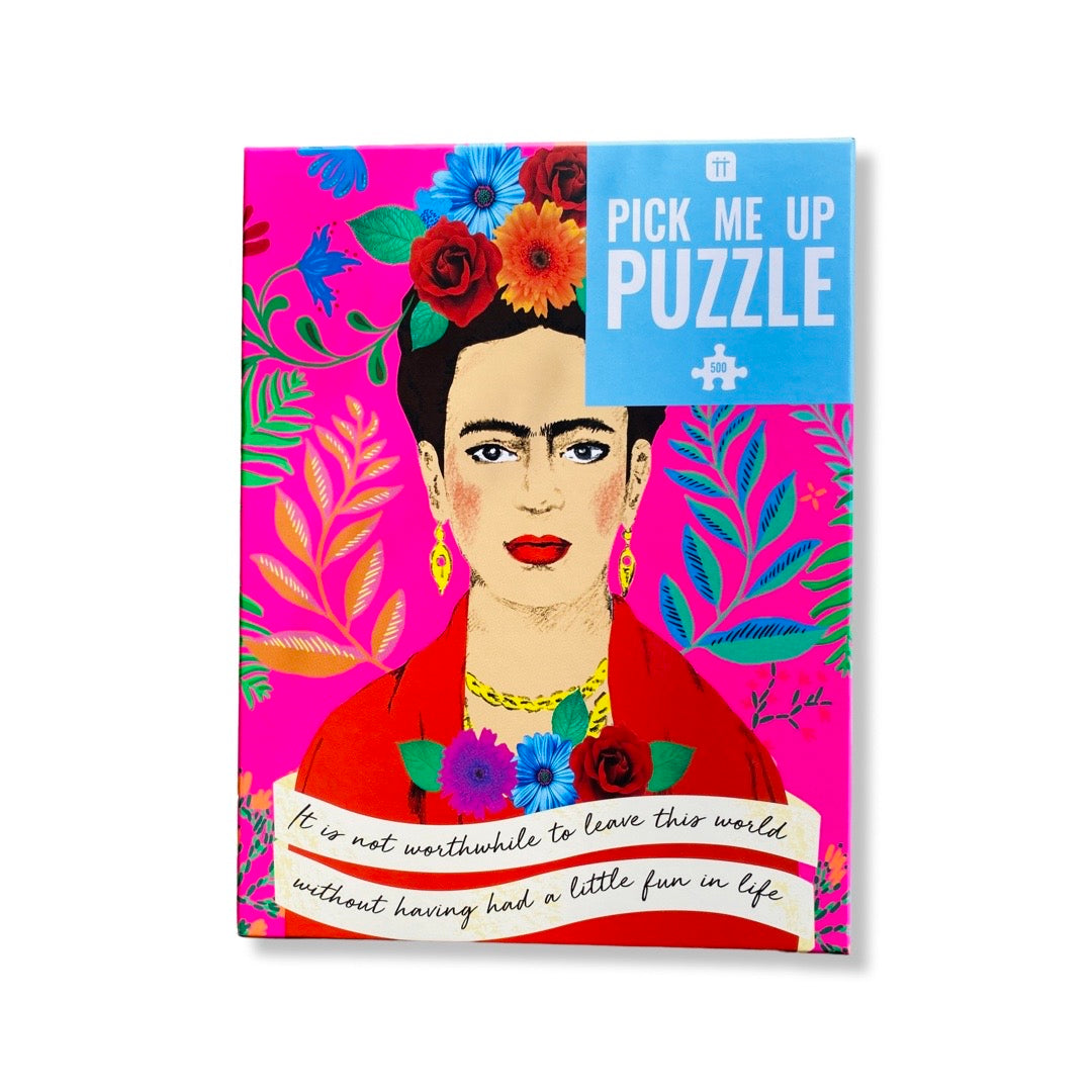 Pink box with Frida Kahlo in front of a floral background with cream banner on the bottom.
