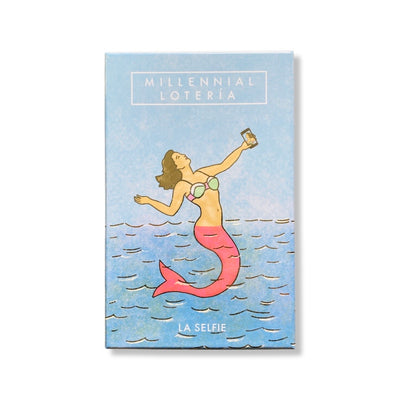 Millennial Loteria card set. Card box graphic features mermaid taking a selfie with the phrase, "La Selfie," underneath. 