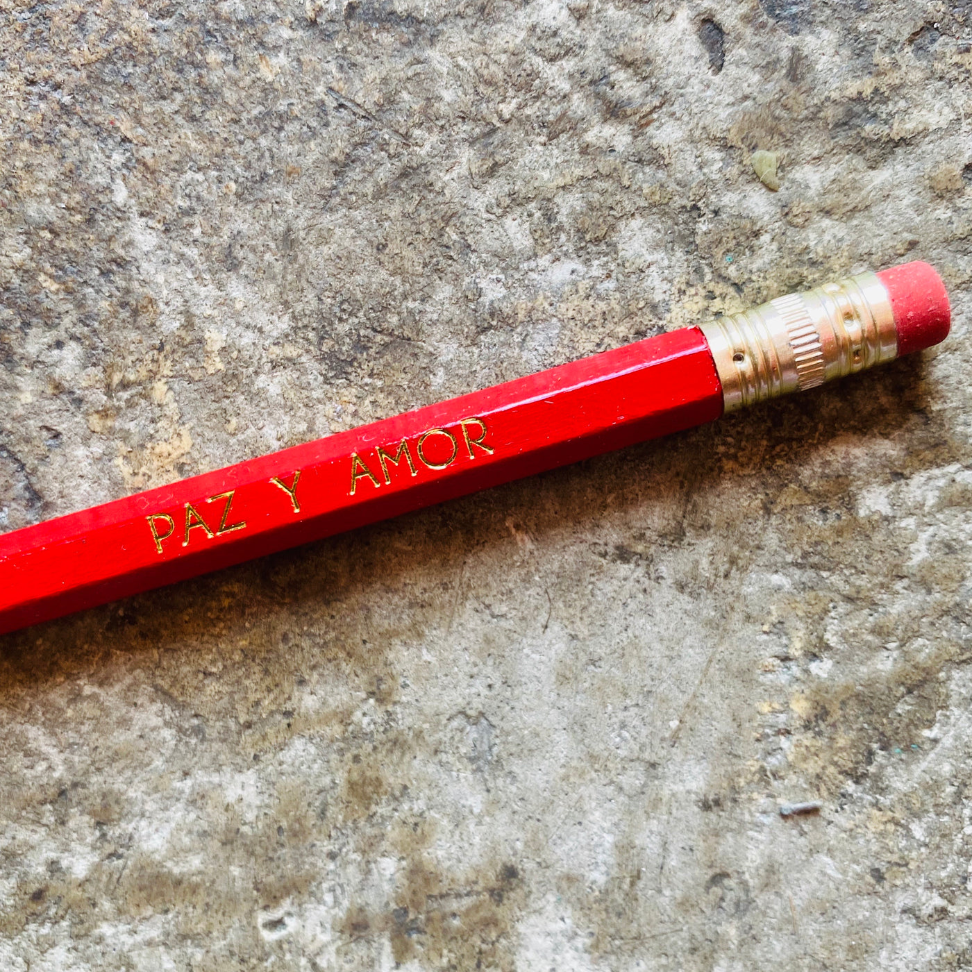 Close up of red paz y amor phrase pencil.