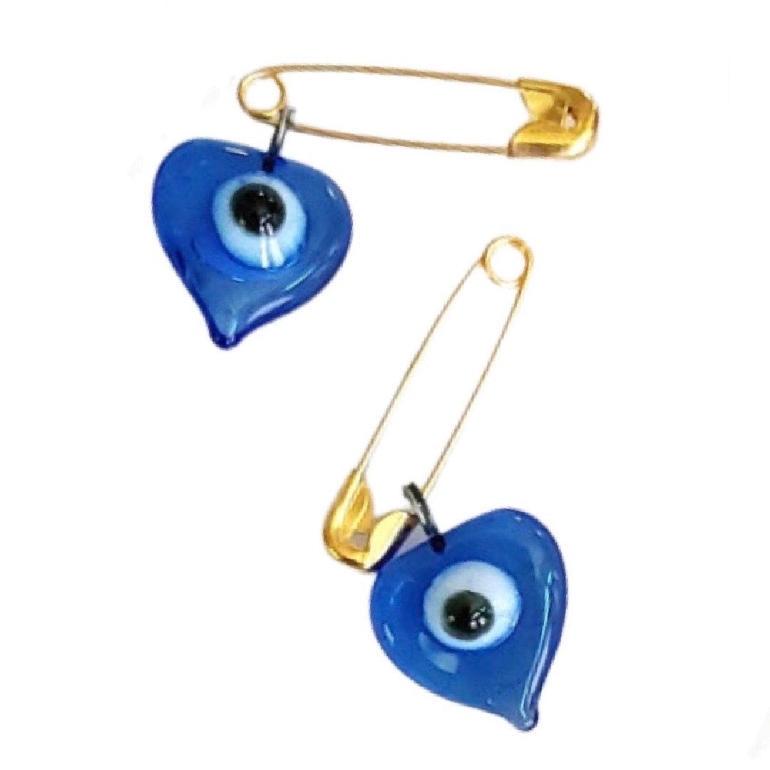 pair of blue glass heart shaped evil eye charms with a gold safety pin