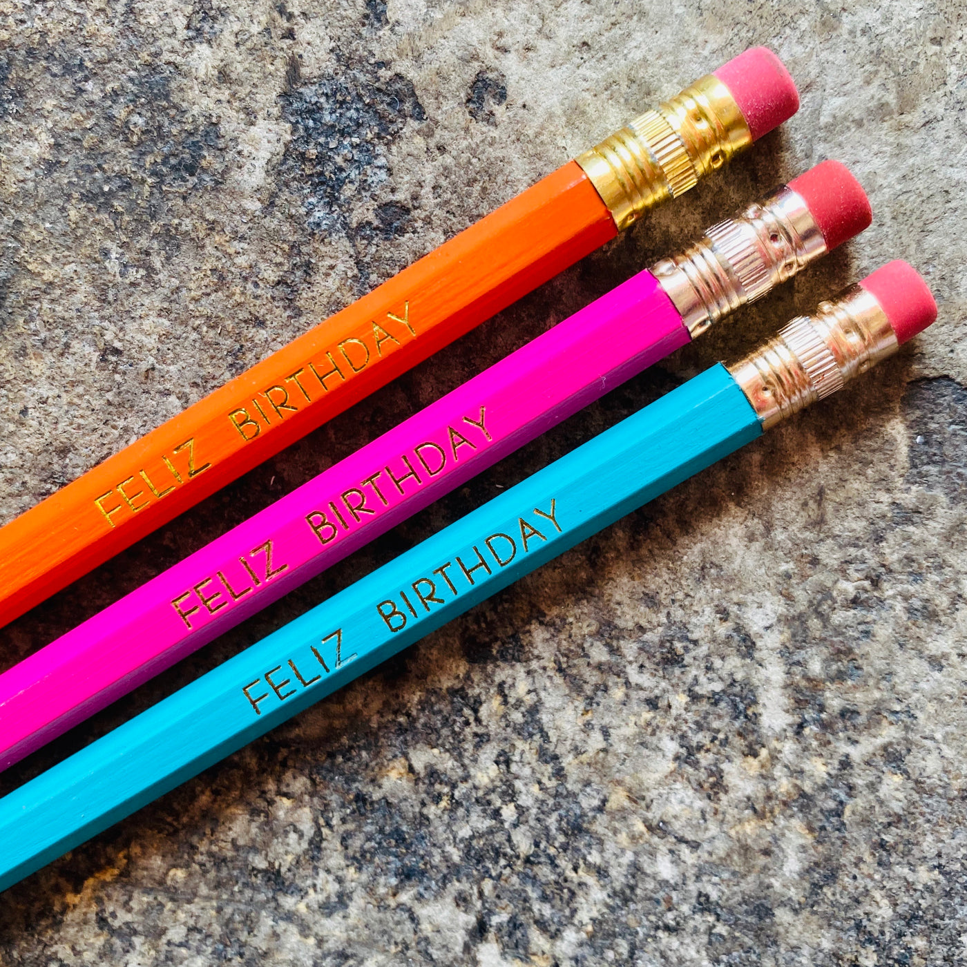 Feliz Birthday phrase pencils in orange, pink, and turquoise. 