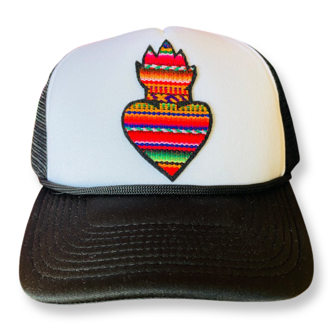 Serape patterned sacred heart trucker hat with black and white accents.