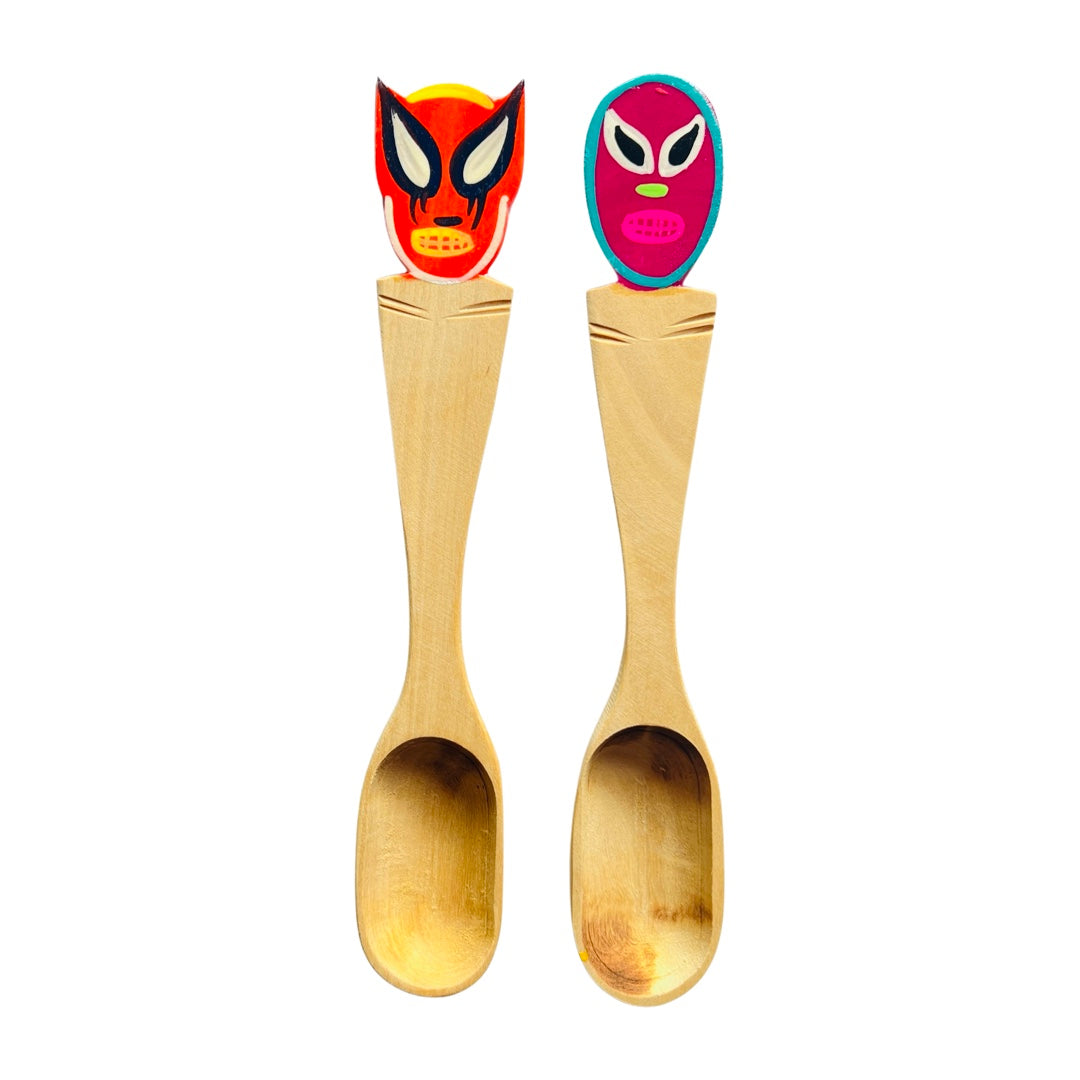 Large colorful Oaxacan painted wooden spoons featuring a luchador mask design