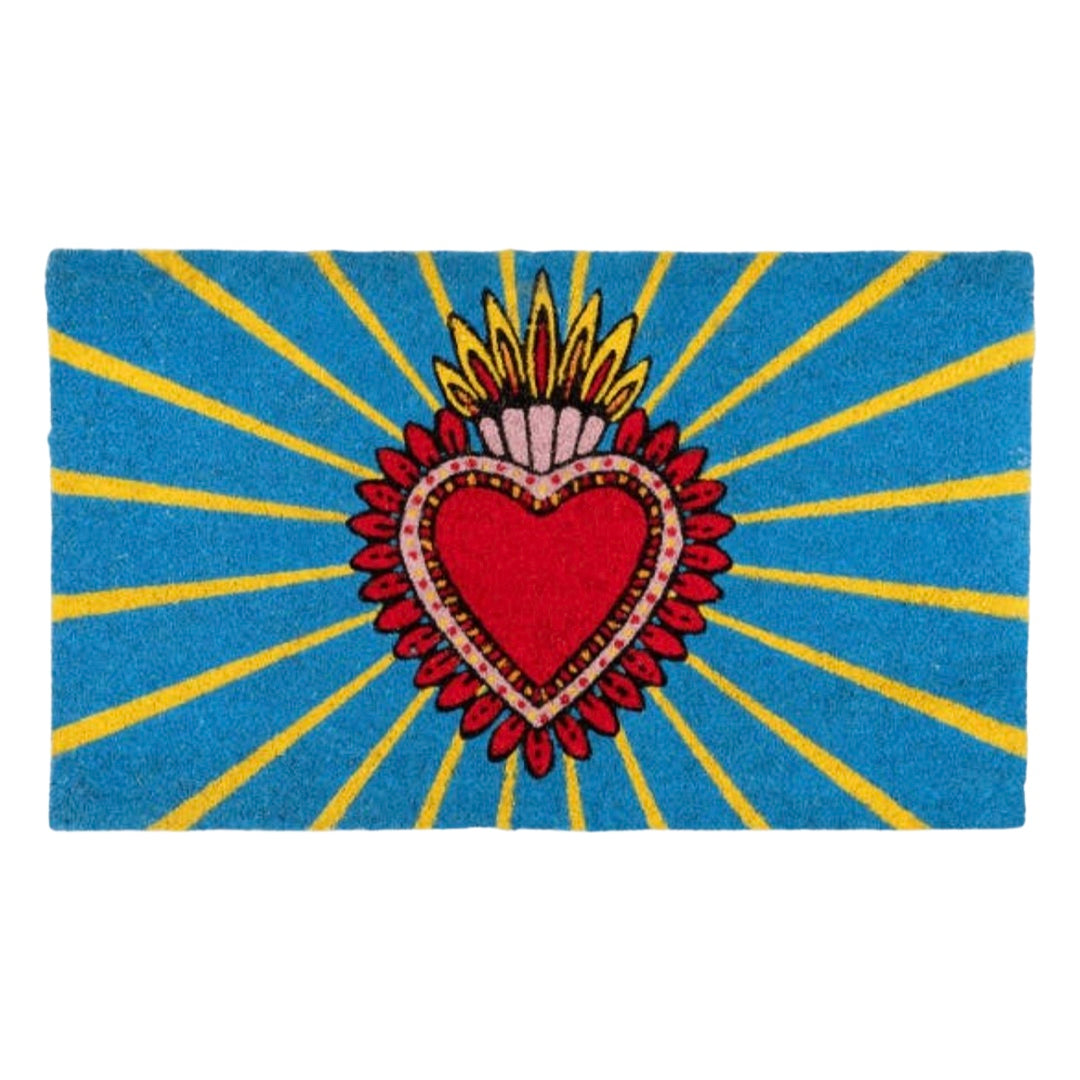 Blue and yellow door mat with a red and pink milagro heart in the center.