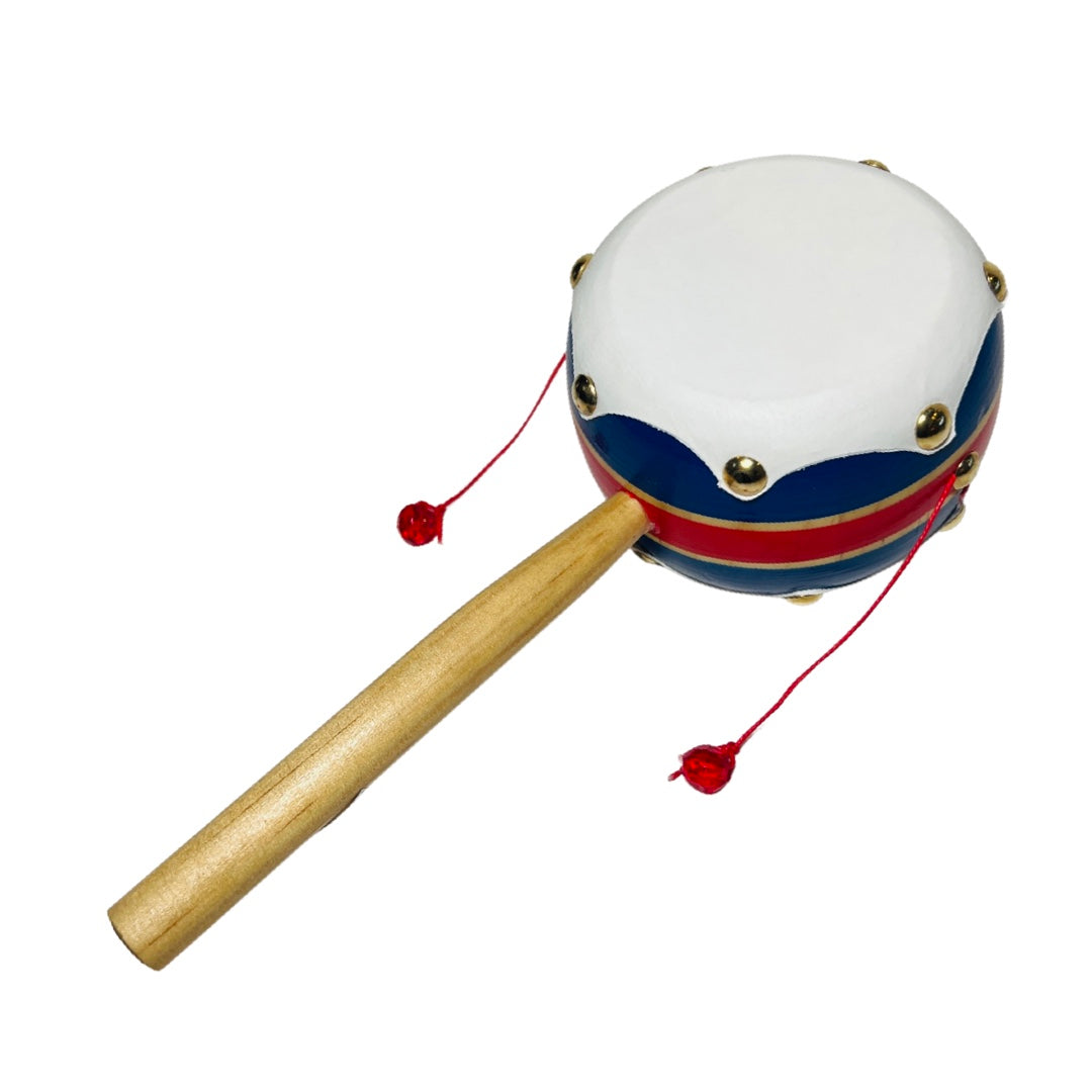 Mexican spinning drum toy with a wooden handle and two strung beads on either side of the white drum head.