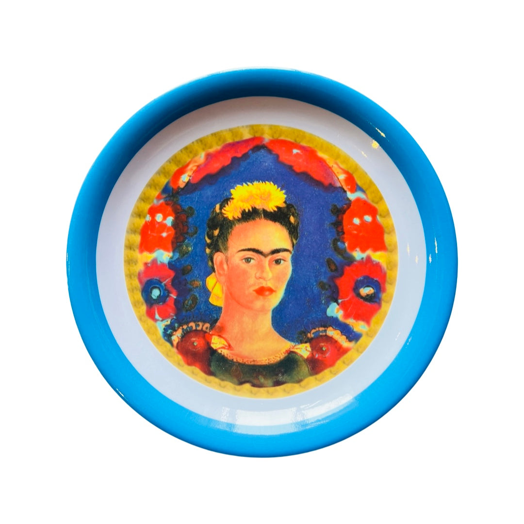 Single melamine plate that features an image of Frida Kahlo in the center and a blue colored rim.